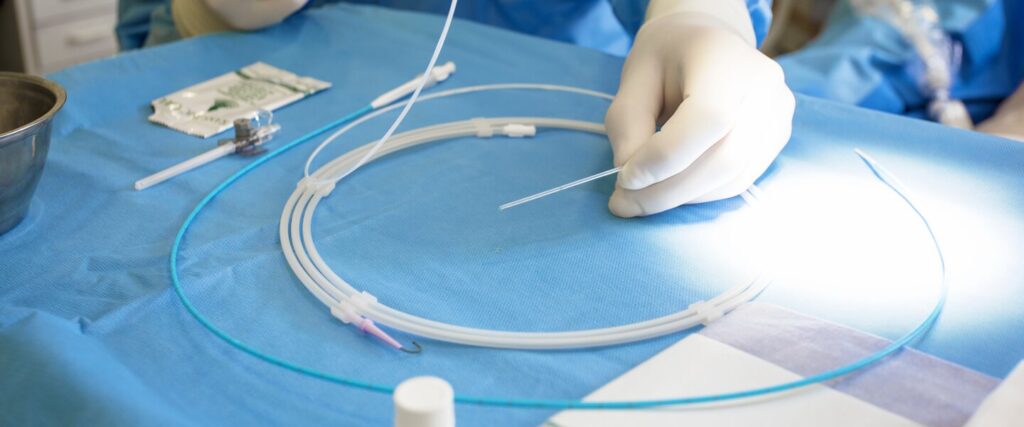 Clinician's hand holding a coated guidewire.