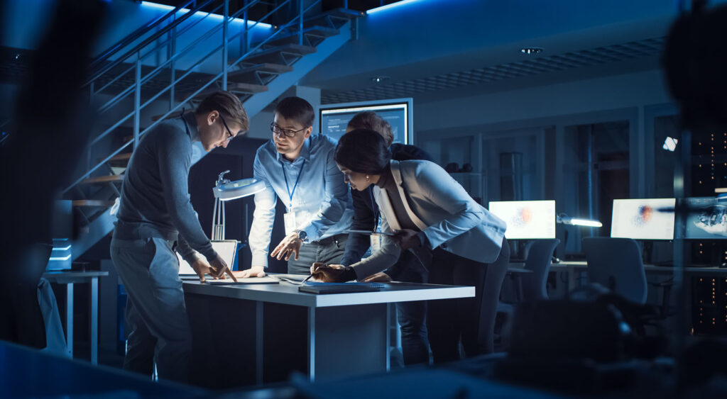 Four business professionals discussing plans in a meeting room.