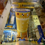 Specialty crane with extra safety and monitoring lifting the Artemis SLS space launch vehicle during manufacturing
